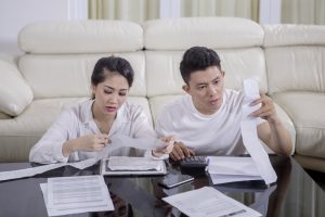 Asian couple checking their bills